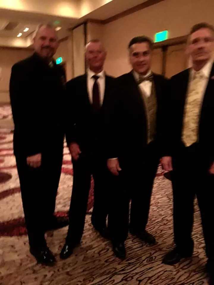 Men in dark suits standing together at the ICHF 25th anniversary celebration.