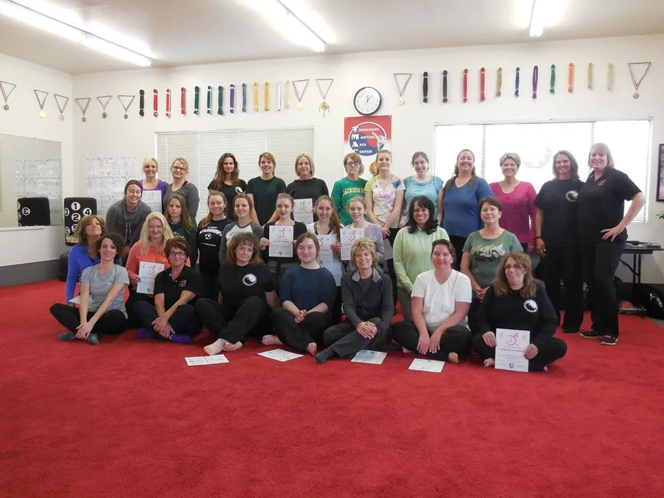A large group of women at a TRU self-defense seminar on the red mat.